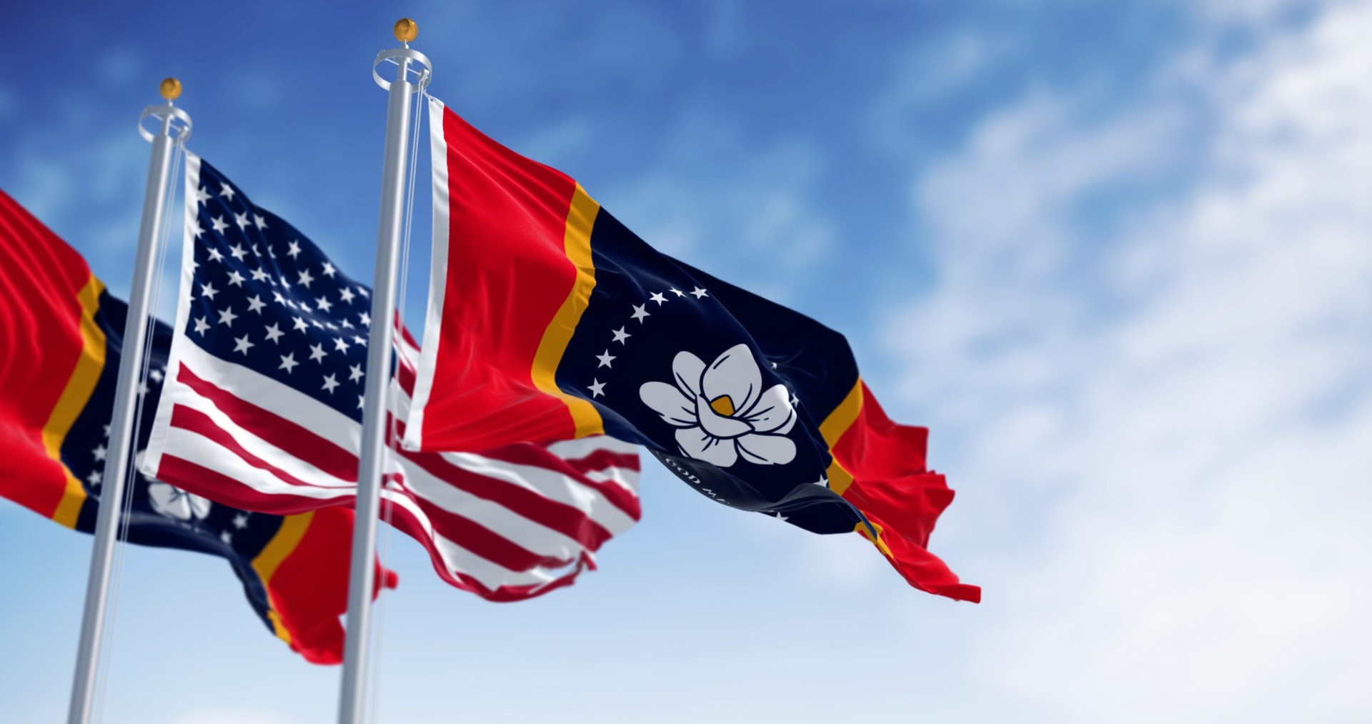 Mississippi state flag waving with the American flag on a clear day